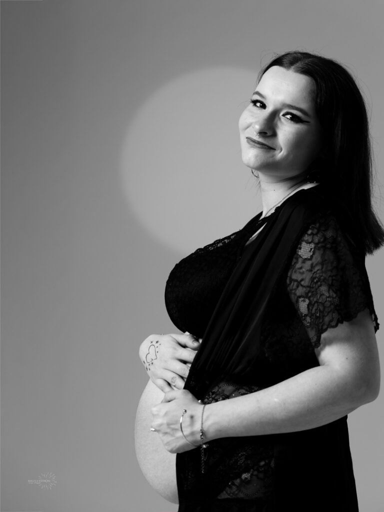 Photographie d'une jeune femme enceinte en clair obscur